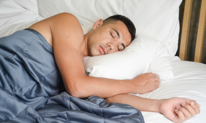 man sleeping with weighted blanket